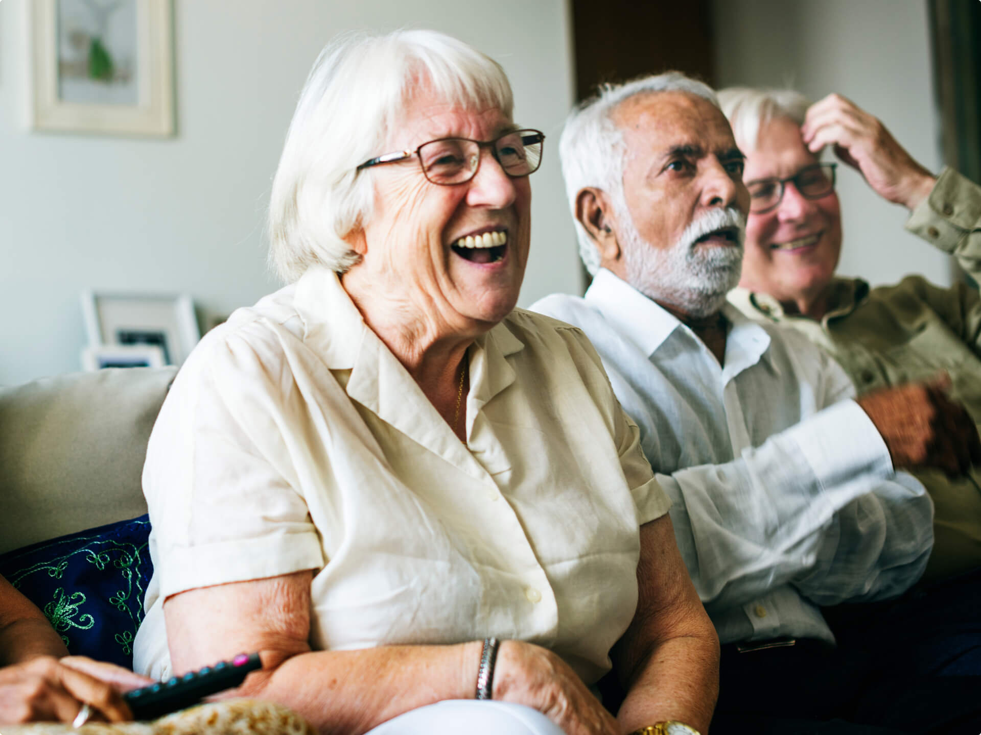 Group of assisted living residents watching a show together on a couch