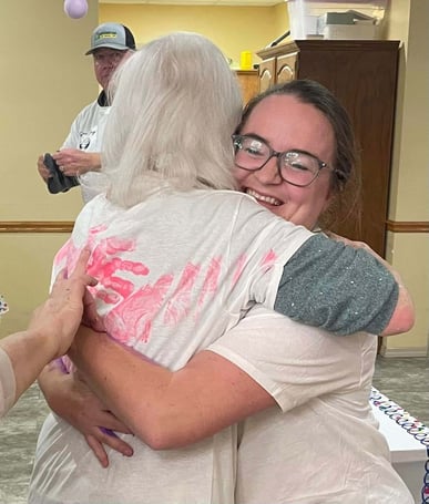 Two women smiling and hugging for the Forever Hug event