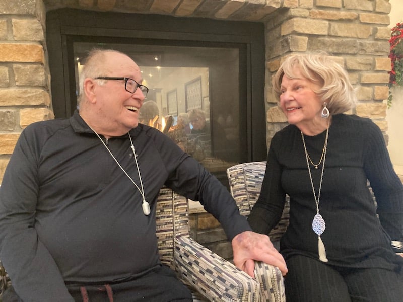 senior couple sitting together in matching outfits