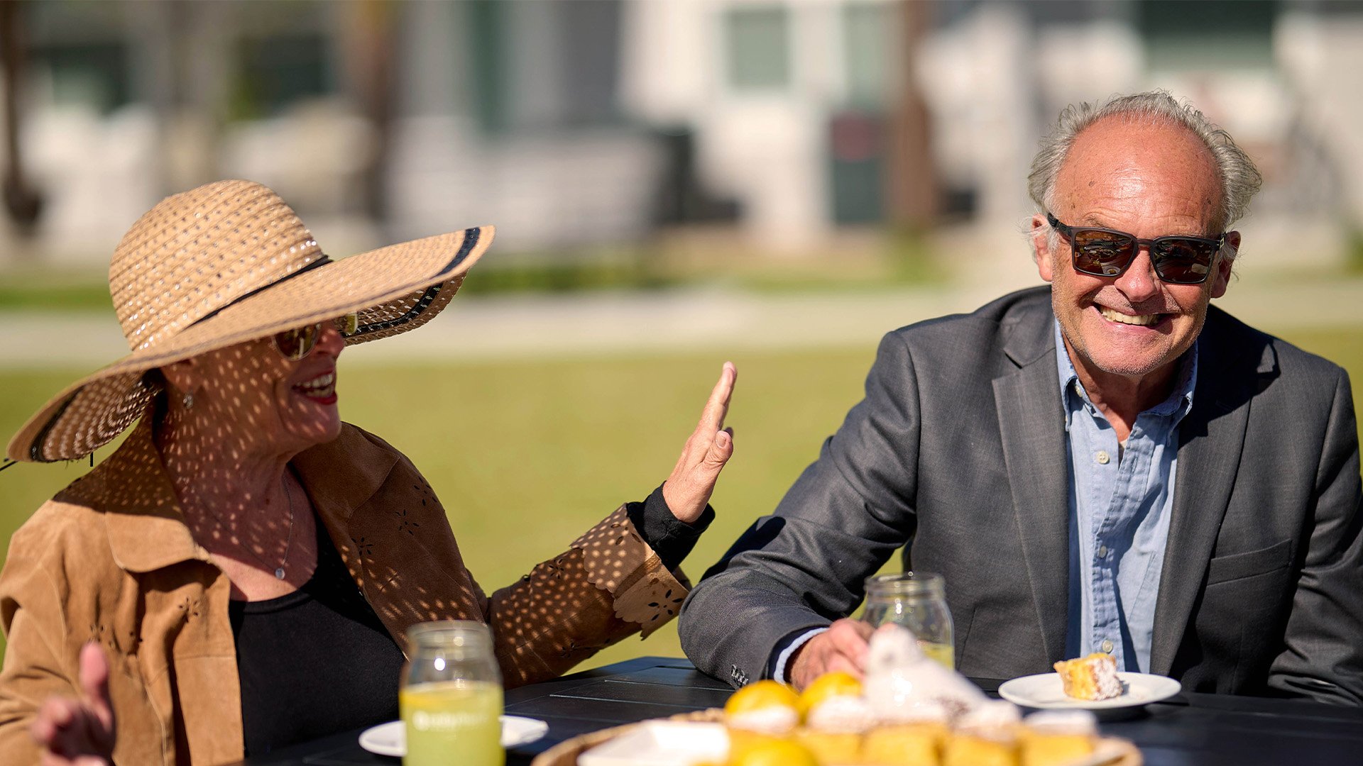 Senior man and woman drinking lemonade outside on a sunny day