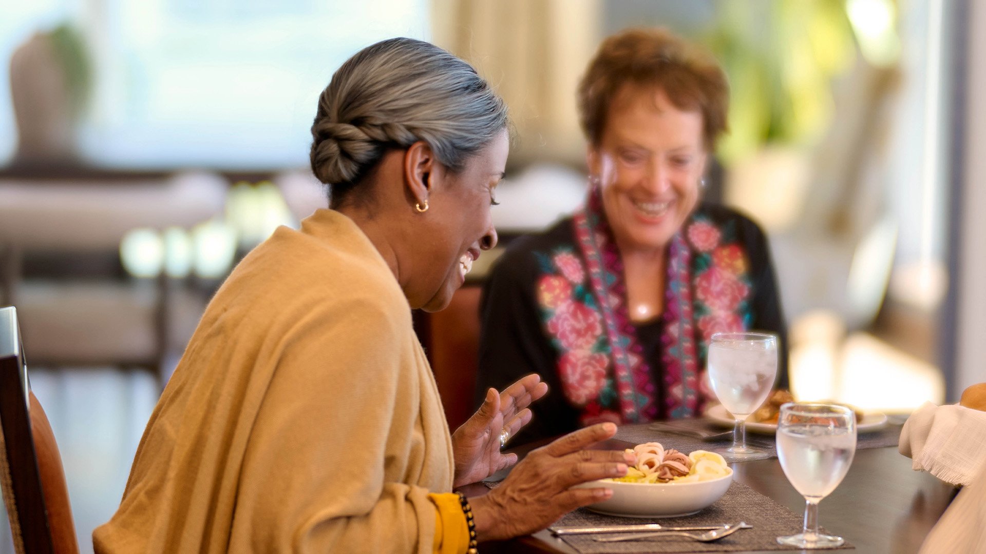 Two senior women eating breakfast together