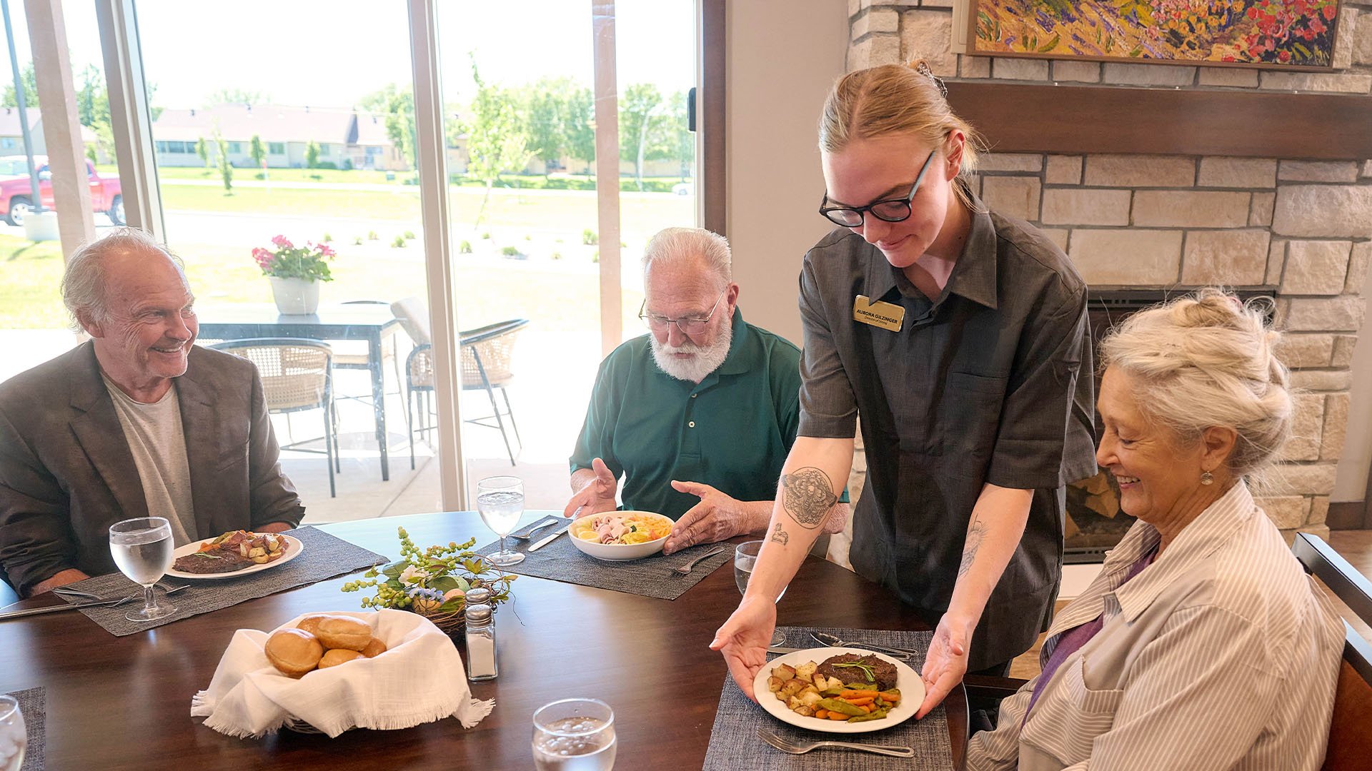 Cedarhurst dining team member serving a plate of food to a senior woman