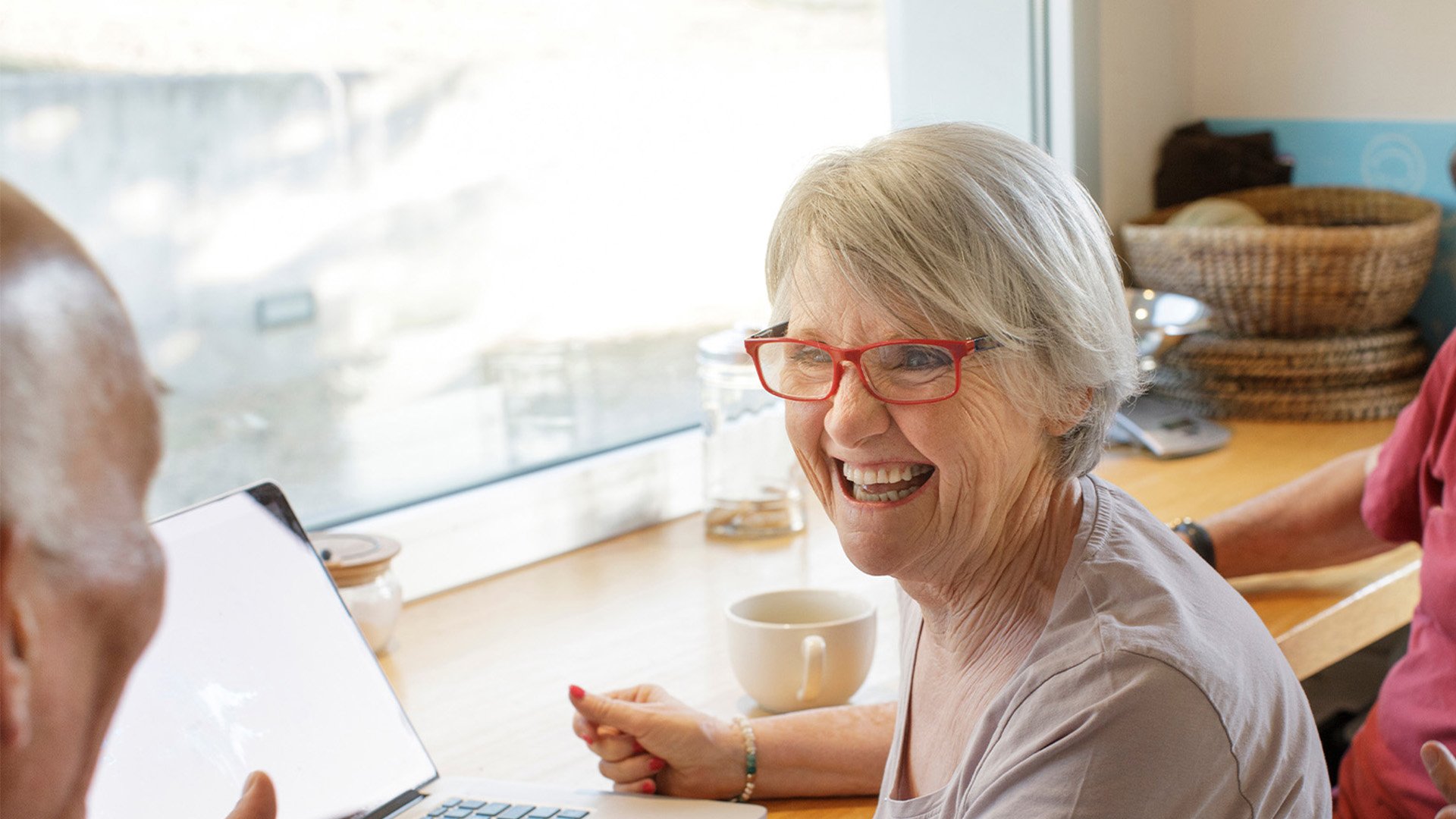 Senior living residents chatting over coffee