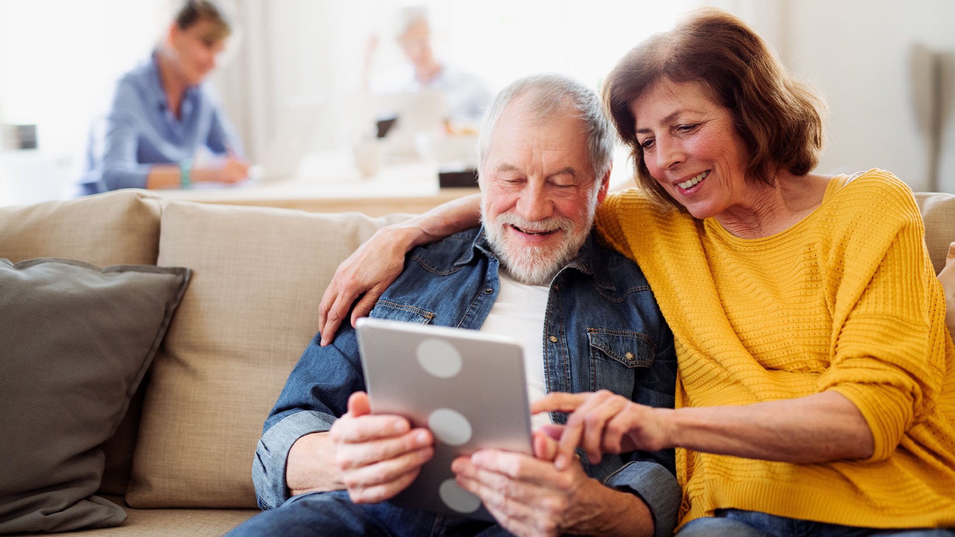 Senior living residents looking an ipad together