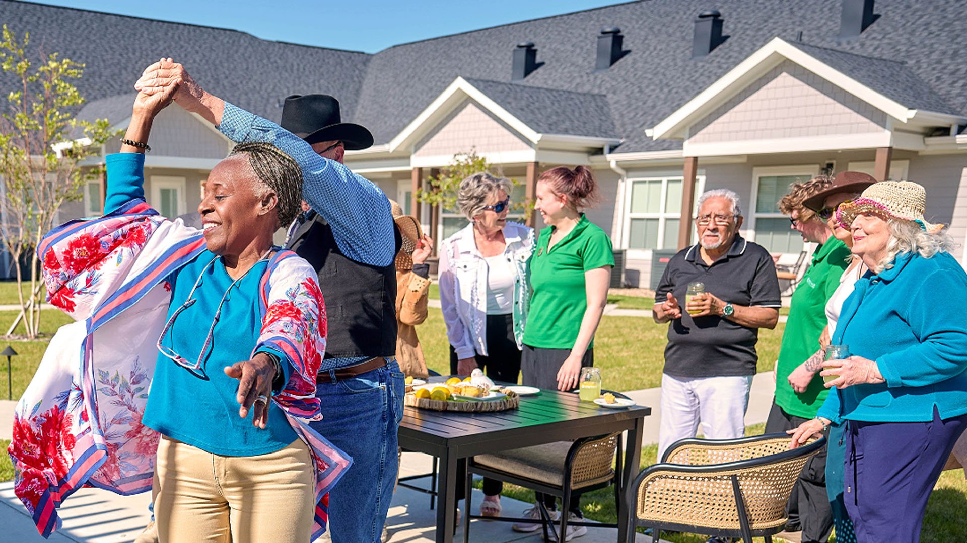 Senior living residents dancing together outside