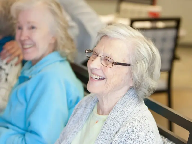 A group of residents smiling together in a living room