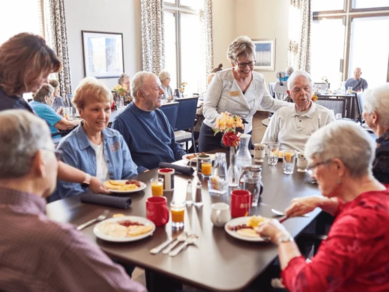 Group of senior living residents enjoying a meal together