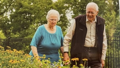 Mr. and Mrs. hart walking in the community garden.