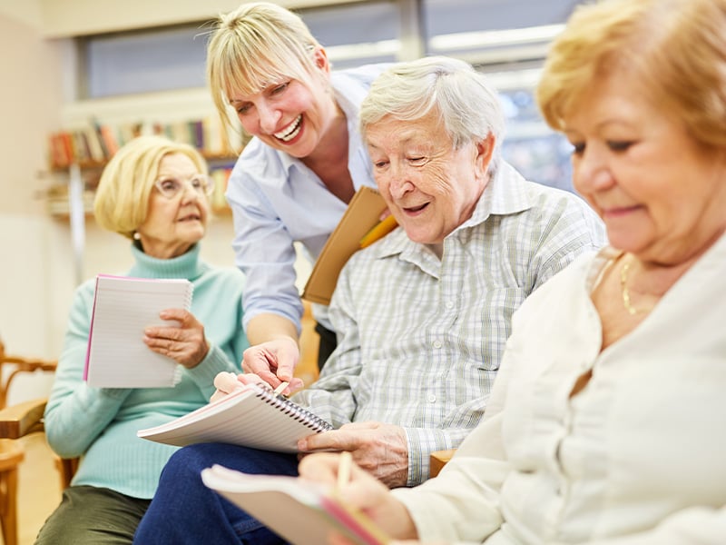 Group of senior living residents taking notes together