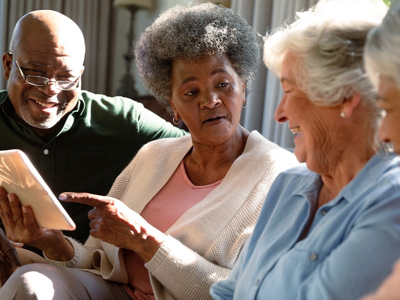 Senior living residents reading a book in living room