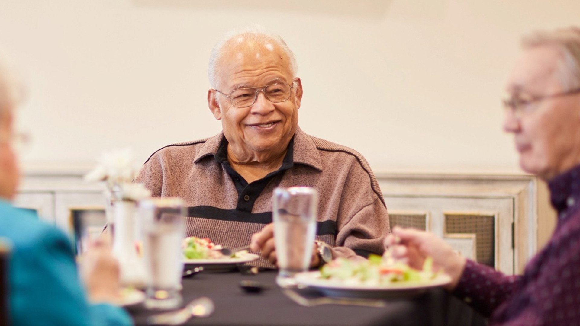 Group of seniors eating together in an intimate dining room