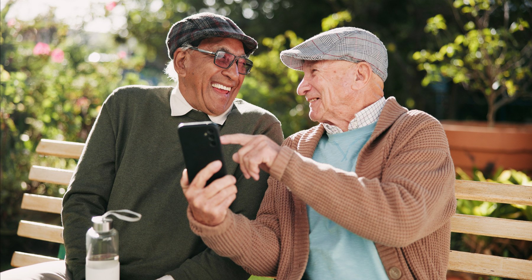 assisted living senior residents smiling while looking at mobile phone