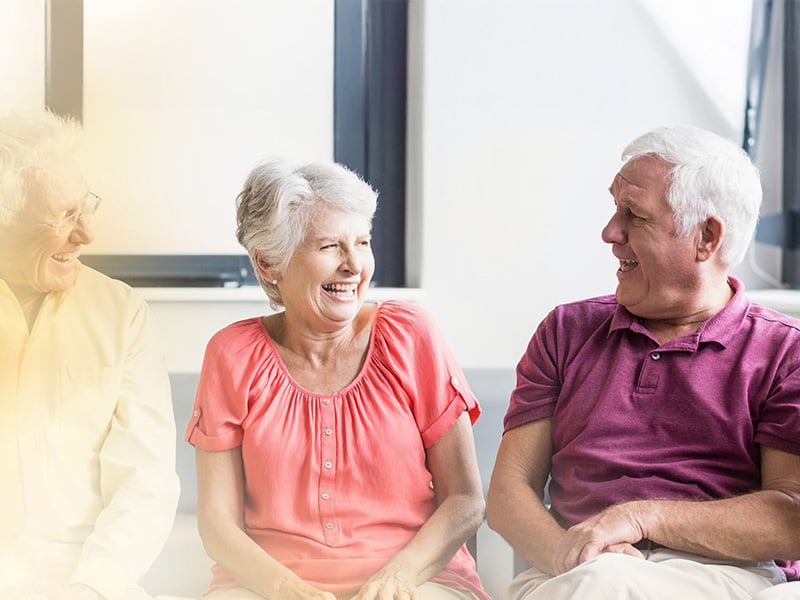 Group of senior living residents smiling together at senior living community