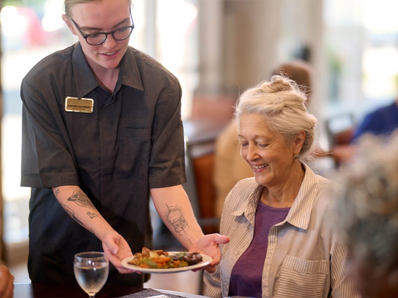 Senior woman being served dinner