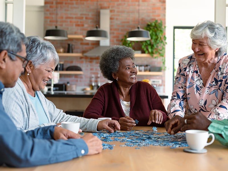 Group of seniors building a puzzle together