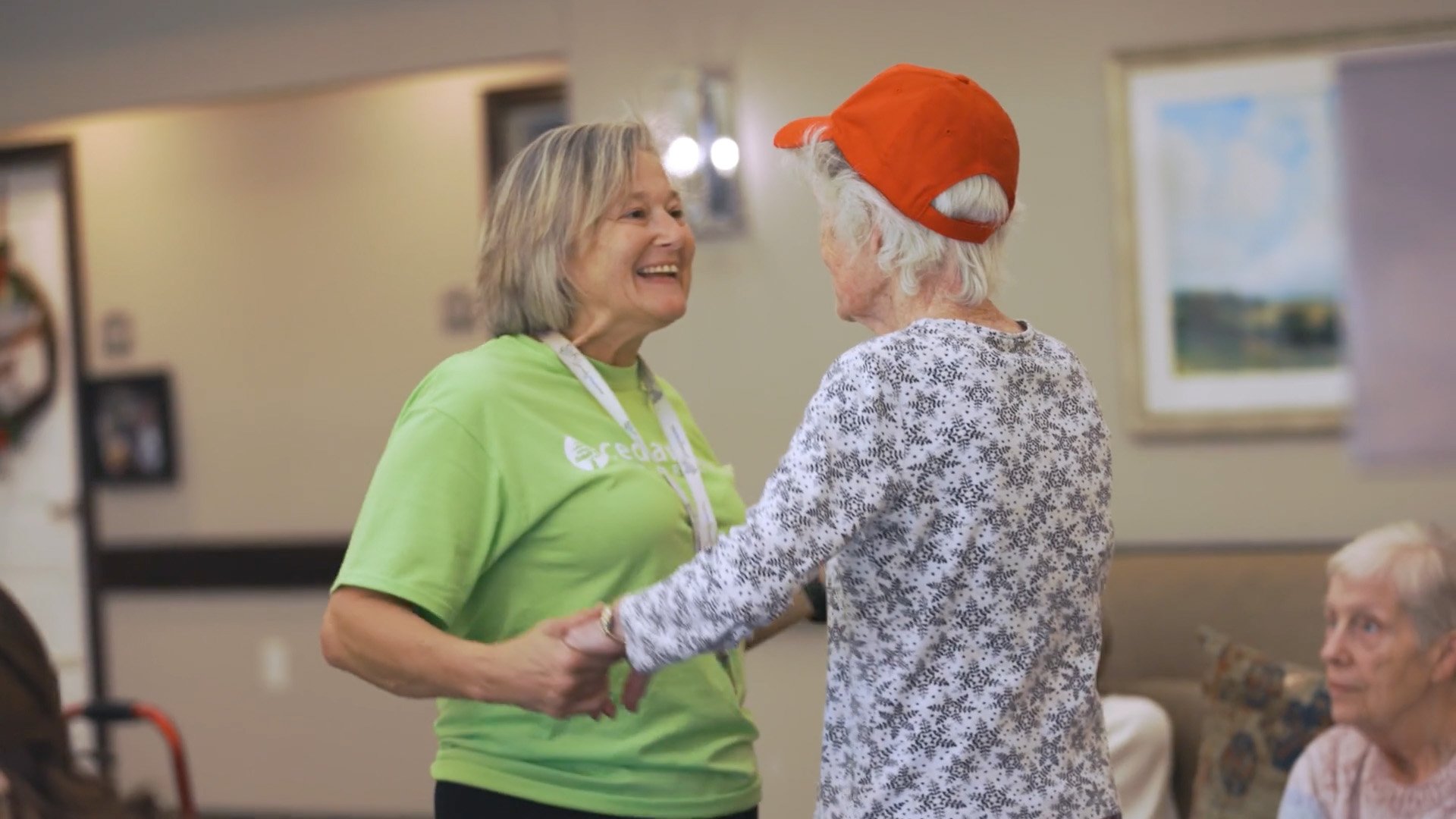 Senior woman dancing with staff member