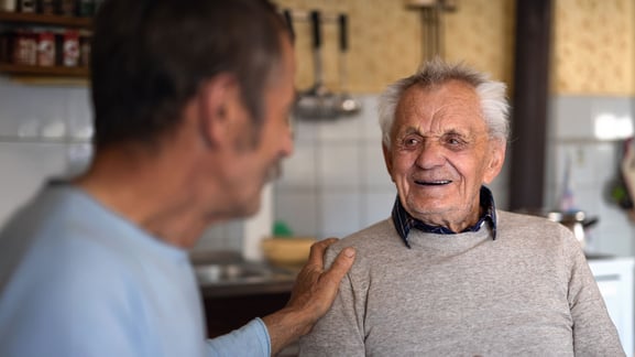 senior man sitting in kitchen