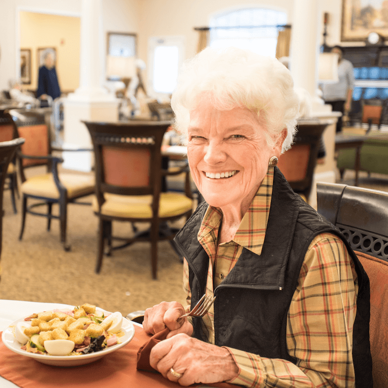 a senior resident eating breakfast in the community dining room