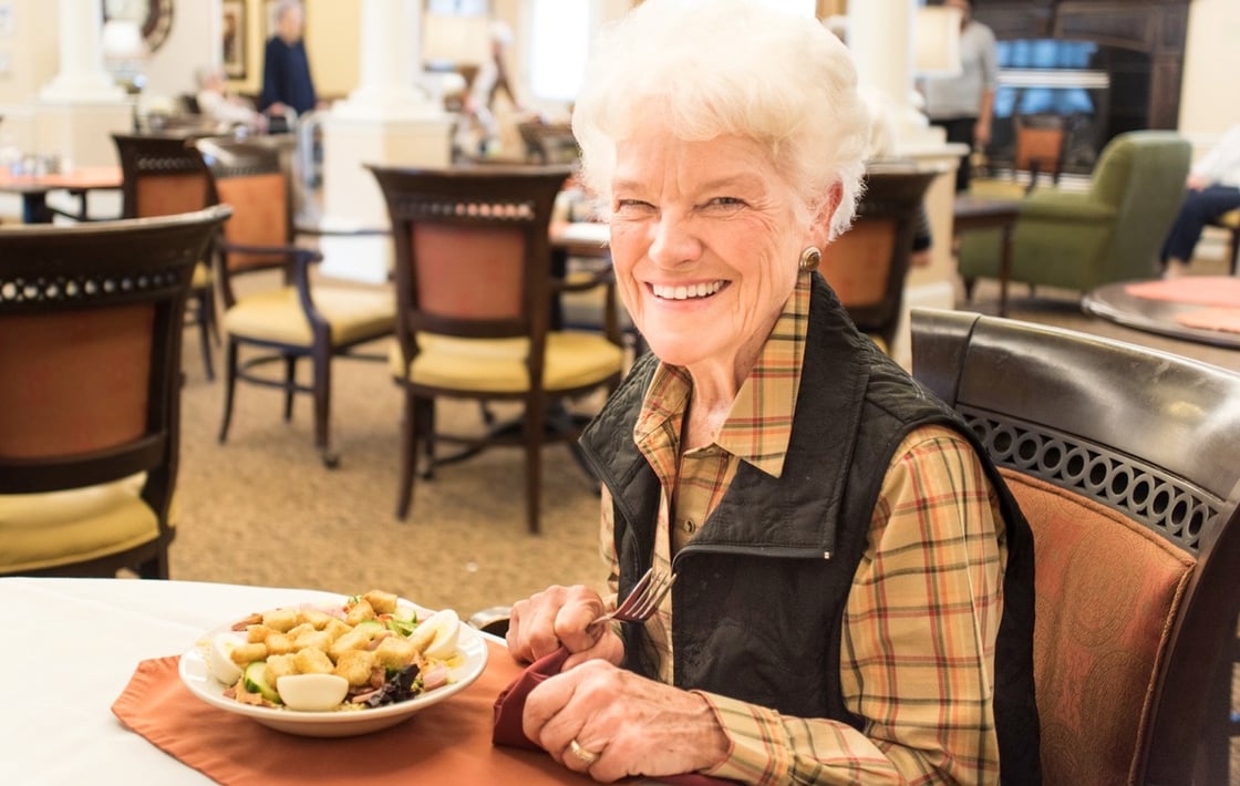 Senior woman eating in the community restaurant