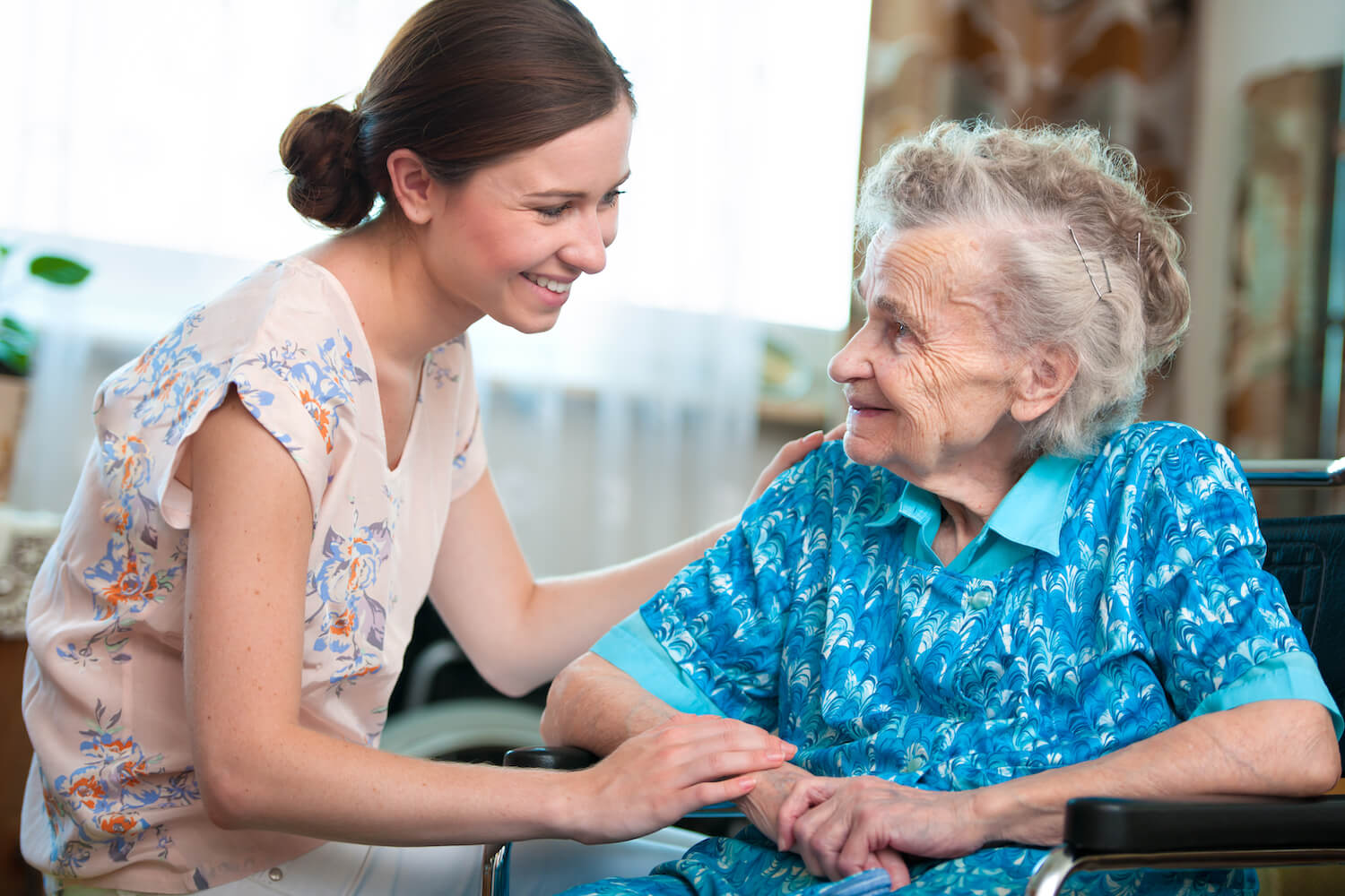 Caregiver sitting with elderly woman