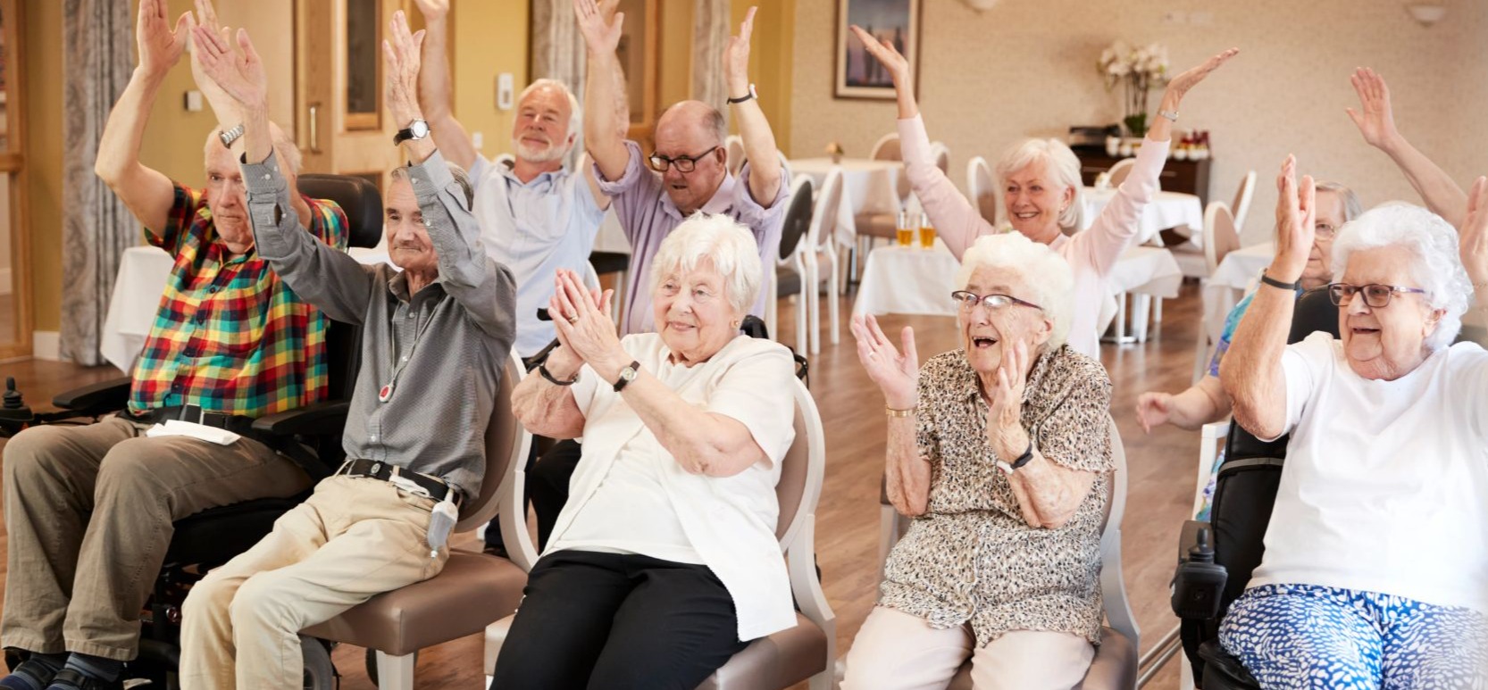 A seated group of senior residents applauding a cheering