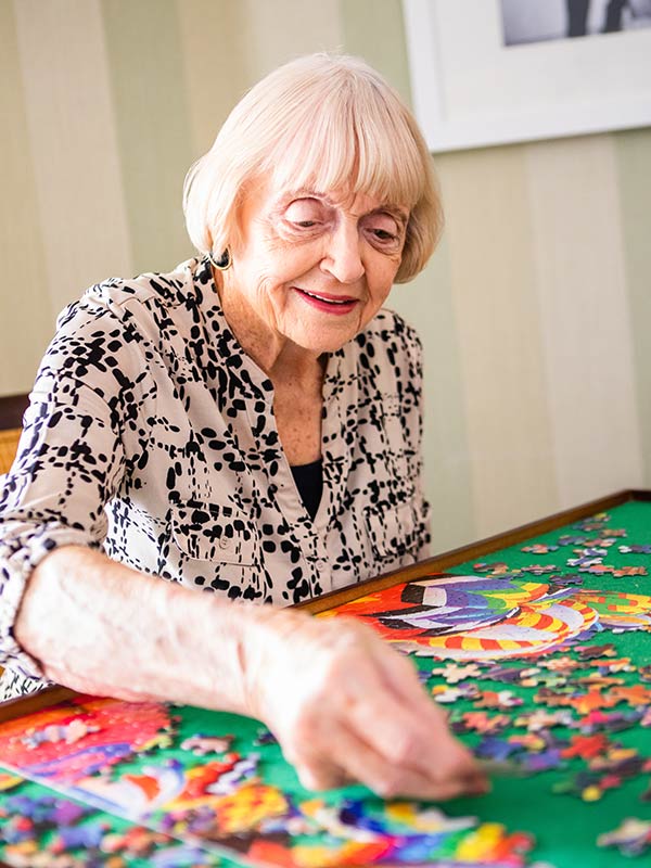 Senior woman completing a jigsaw puzzle