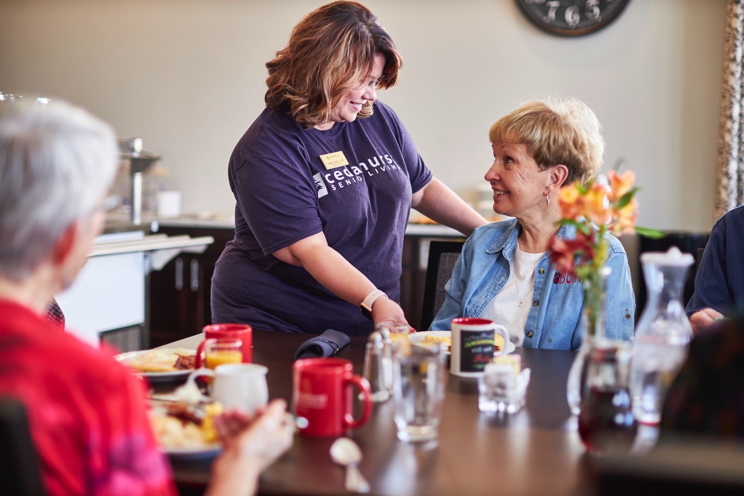 Senior having breakfast with staff member