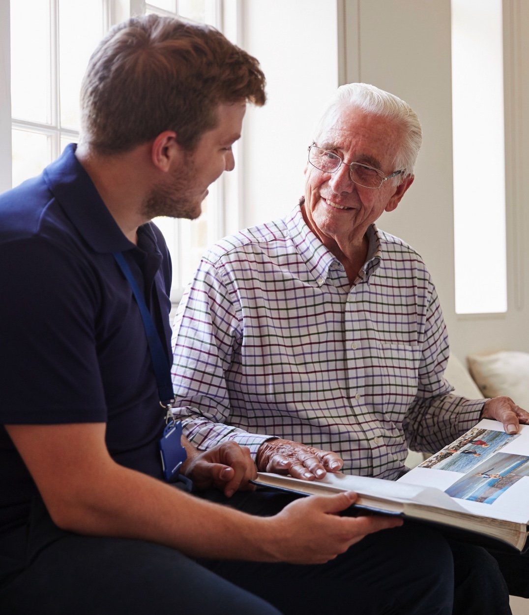 Senior man and younger man looking at a photo album