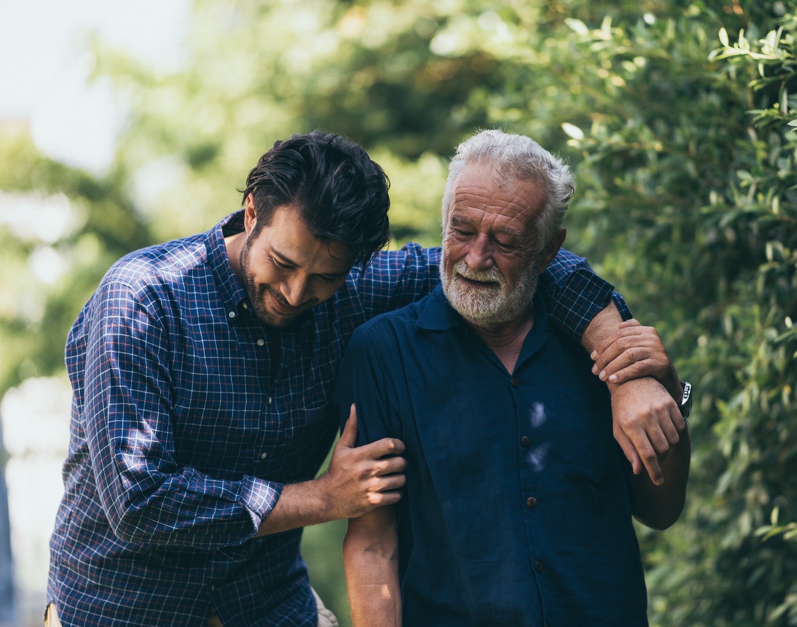 The old man and his son are walking in the park