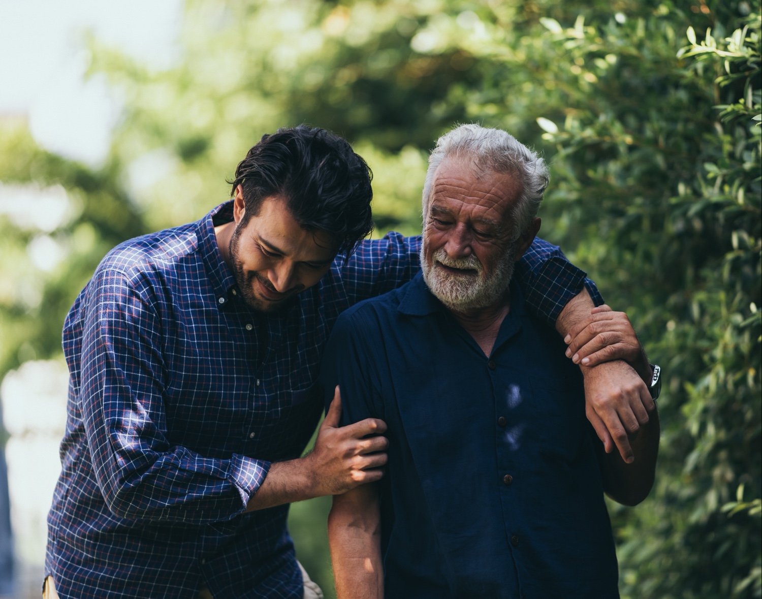 The old man and his son are walking in the park