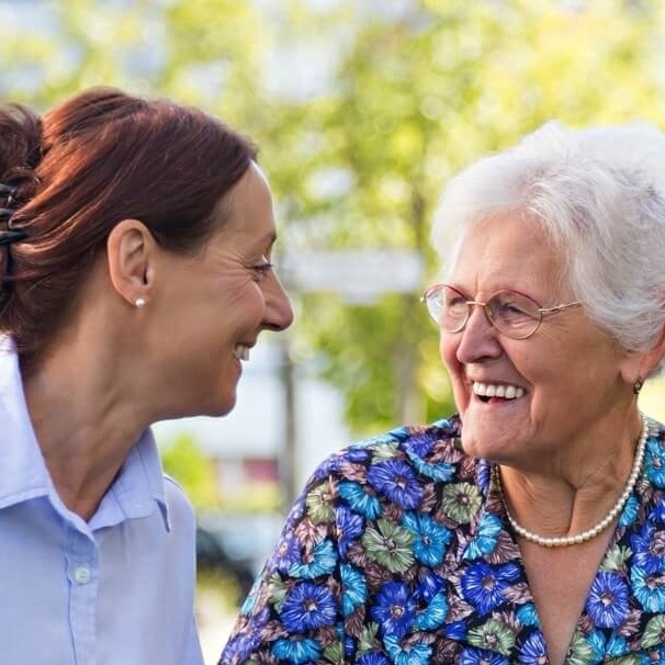 Carer helping senior with walker outdoors-1-1