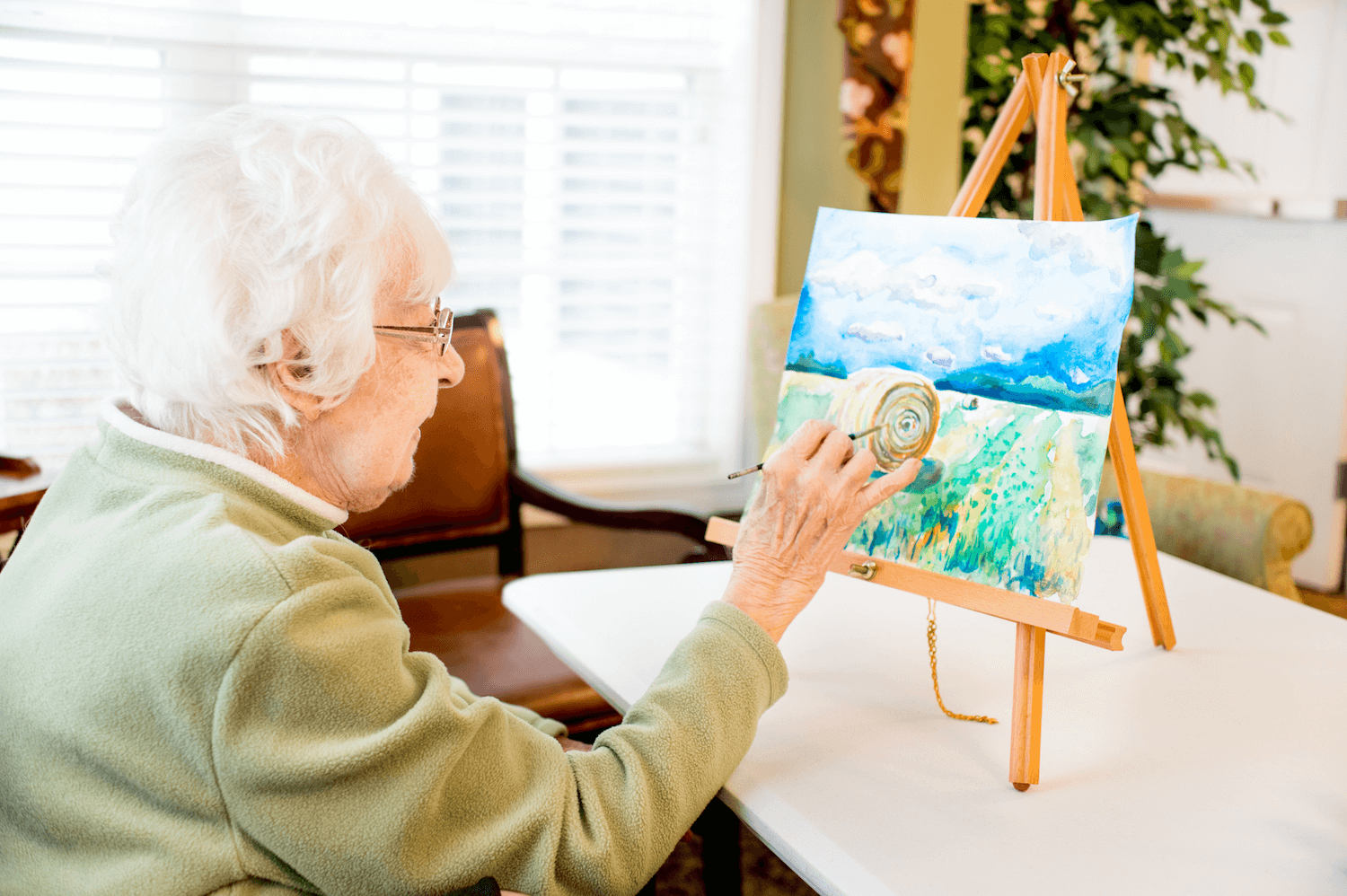 Senior resident participating in a painting class