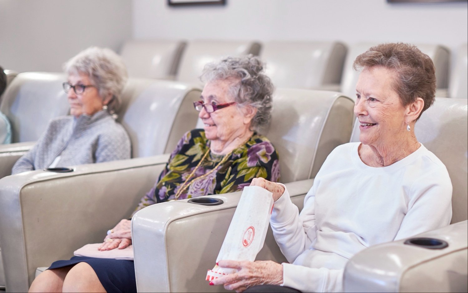 Seniors watching movie and eating popcorn