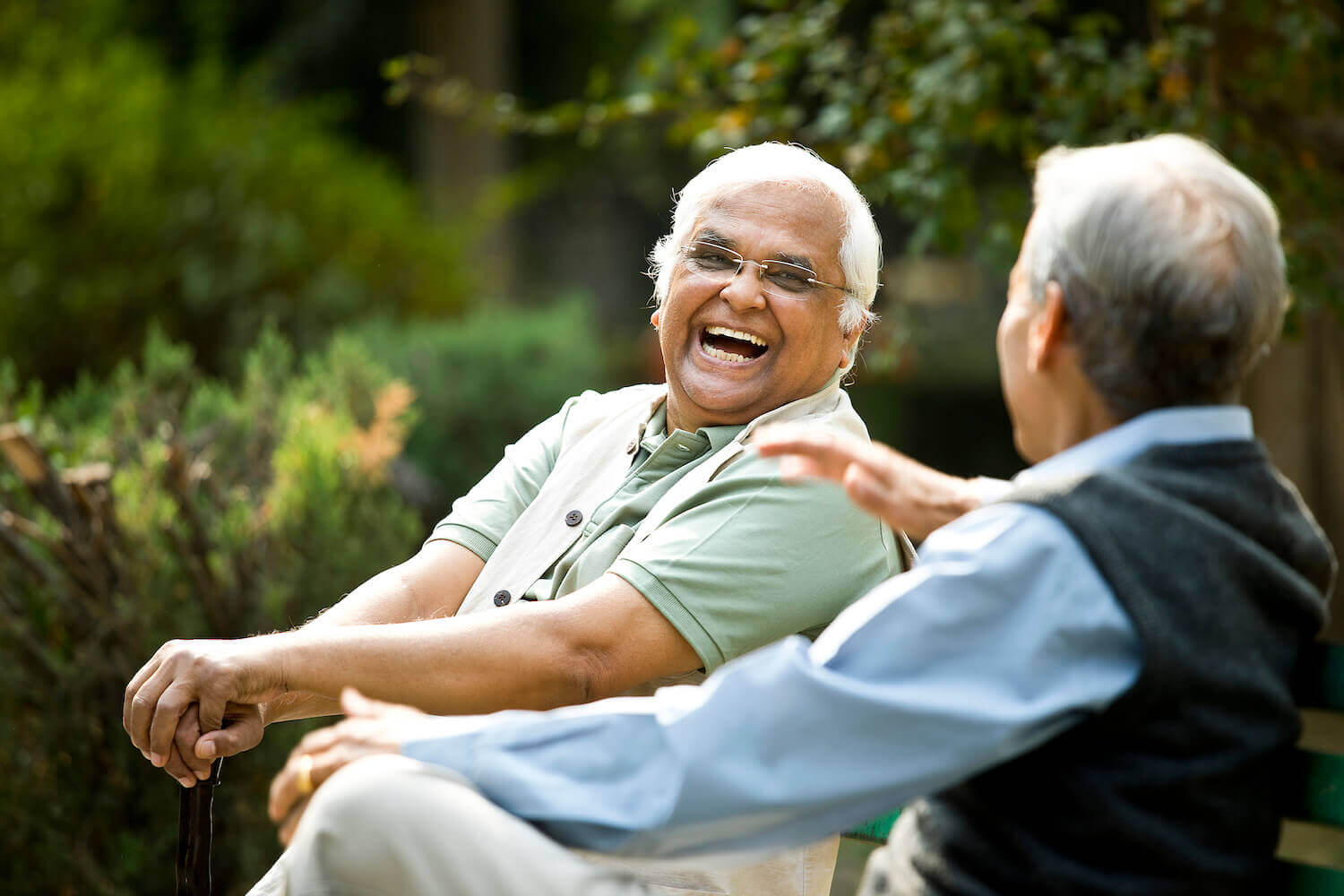 Senior man sitting on a bench with a friend