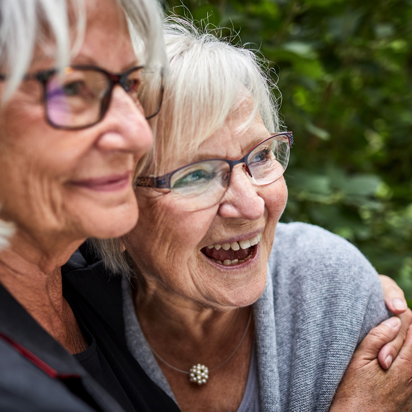 An senior family caretaker embracing a memory care resident