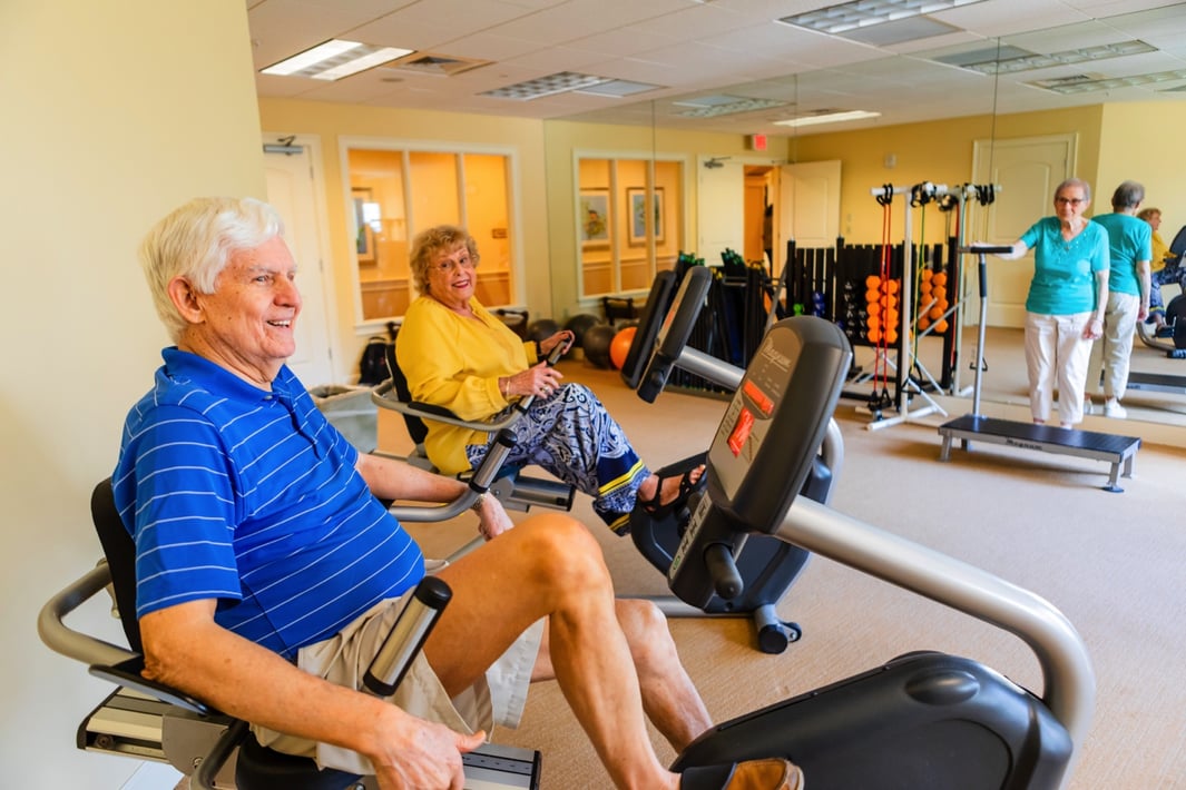 Senior couple exercising on recumbent bicycles in the fitness center