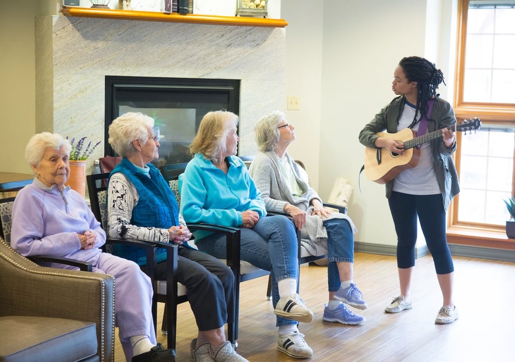 Four senior residents listening to a live music performance