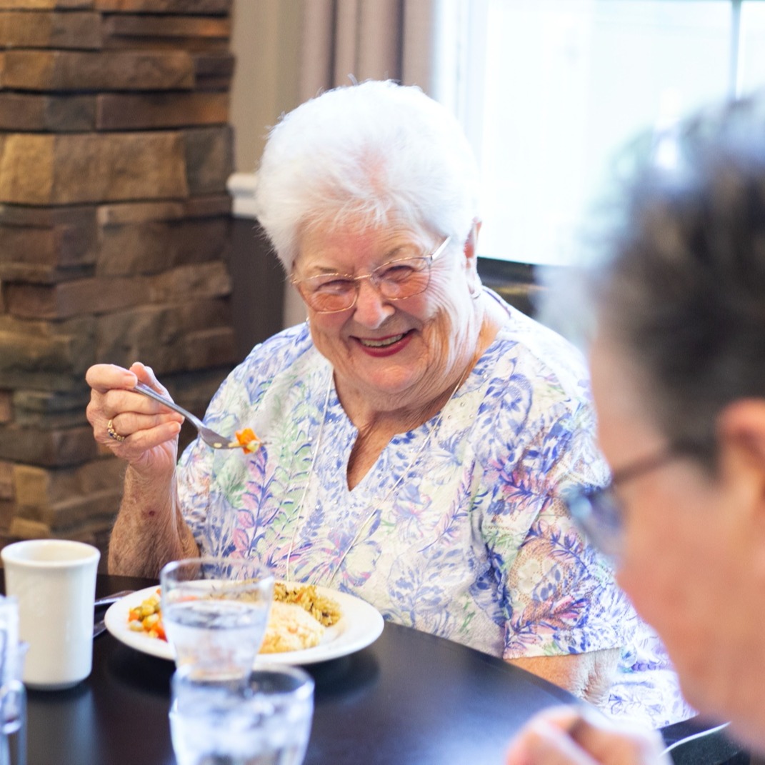 Residents smiling and enjoying breakfast together