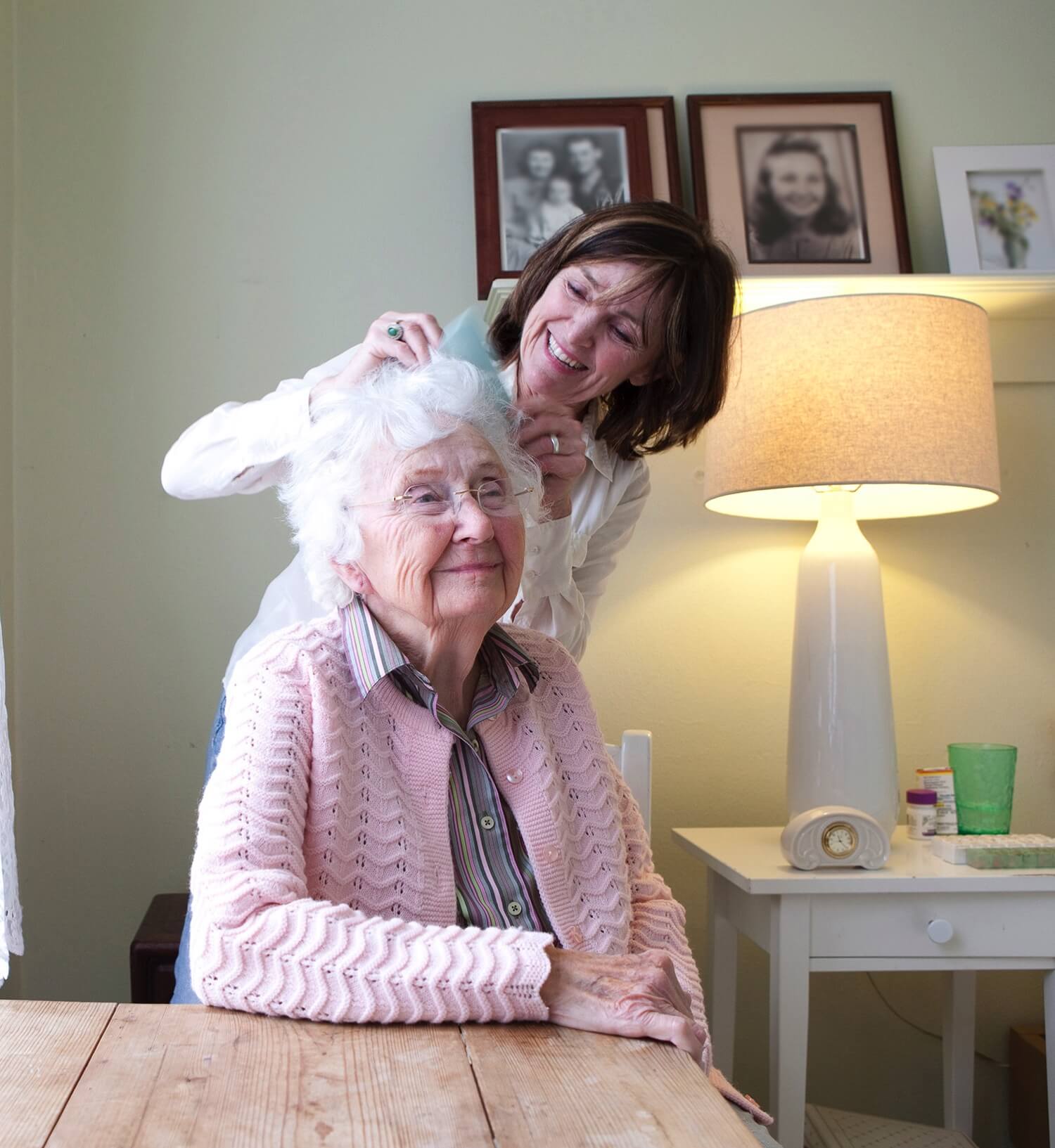 Team member helping a senior resident brush her hair