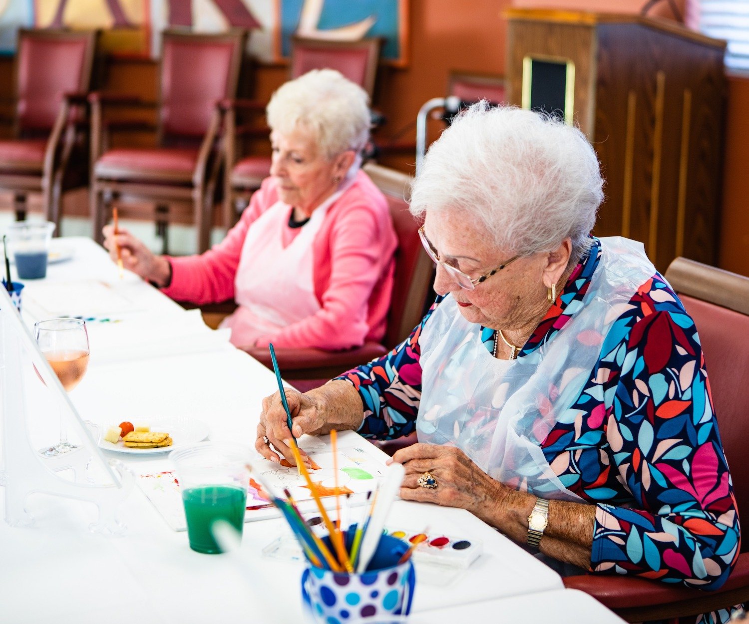 Elderly women painting in class