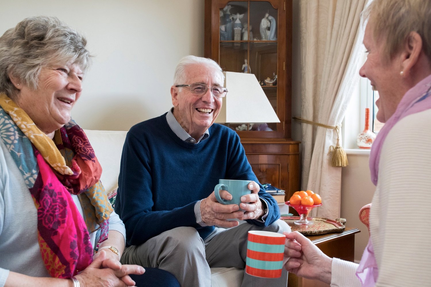 Group of senior friends drinking coffee in a private living room