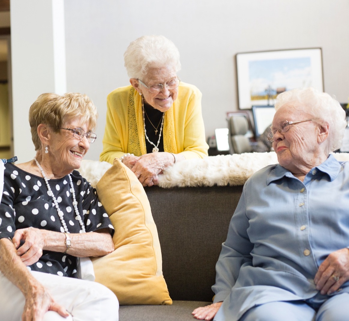 Group of seniors laughing on couch Group of seniors laughing on couch