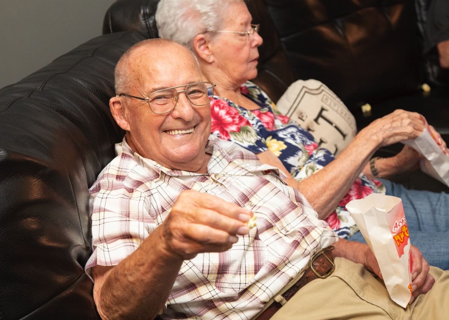 Happy elderly man eating popcorn