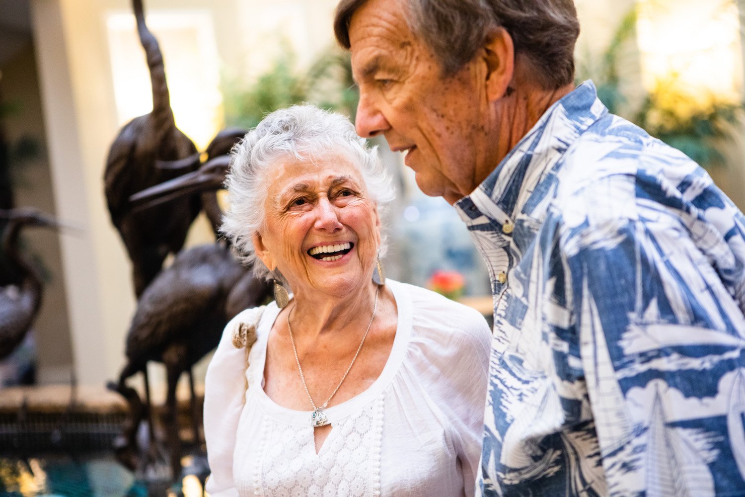 Senior man and woman laughing together in the community lobby