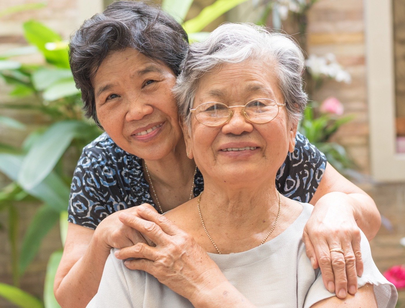Two senior women embracing and smiling at the camera