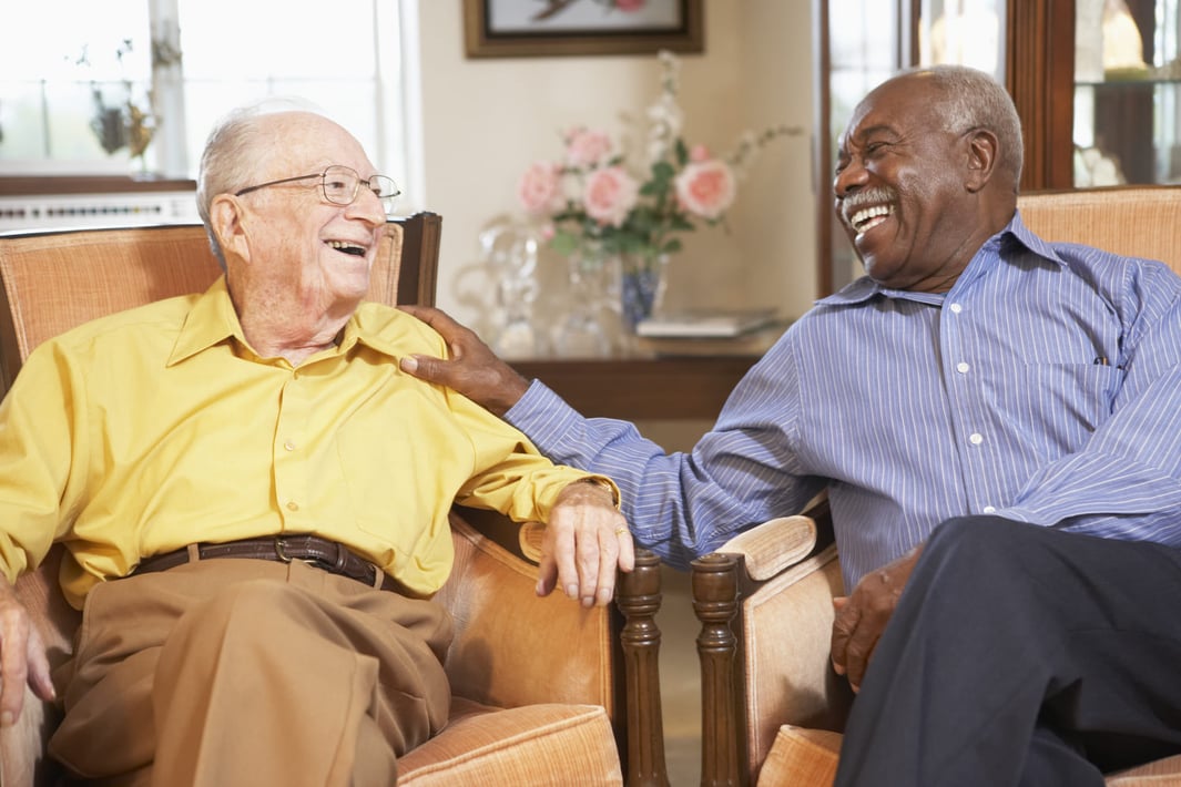 two senior men laughing and smiling together