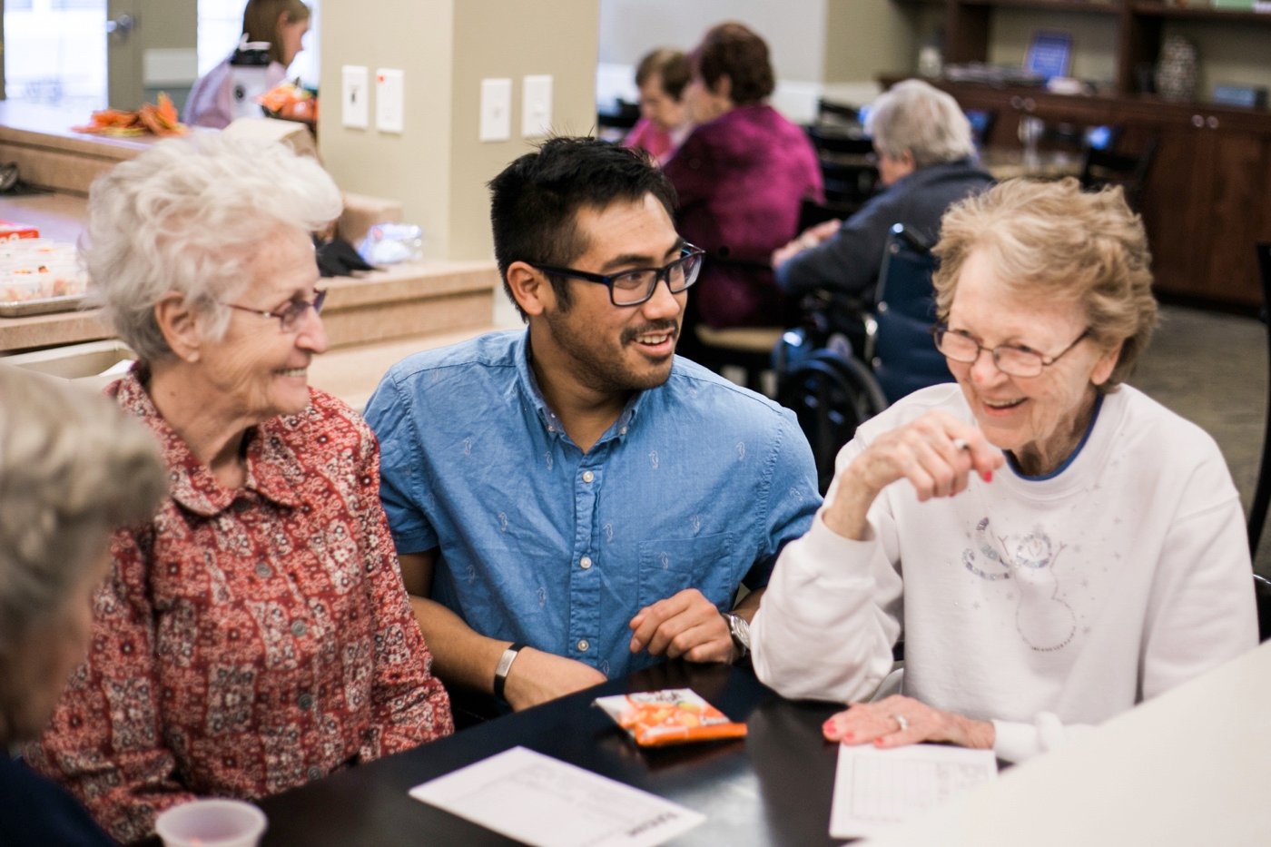 Senior woman and staff member playing cards