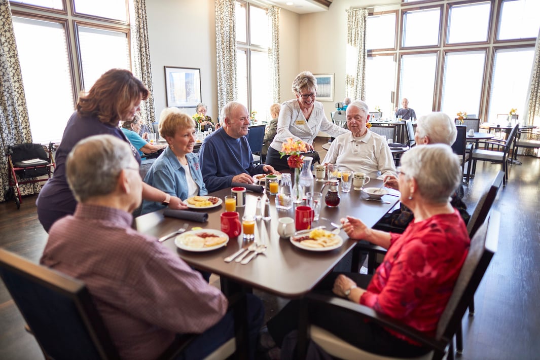 Staff members serve a group of seniors in the community restaurant