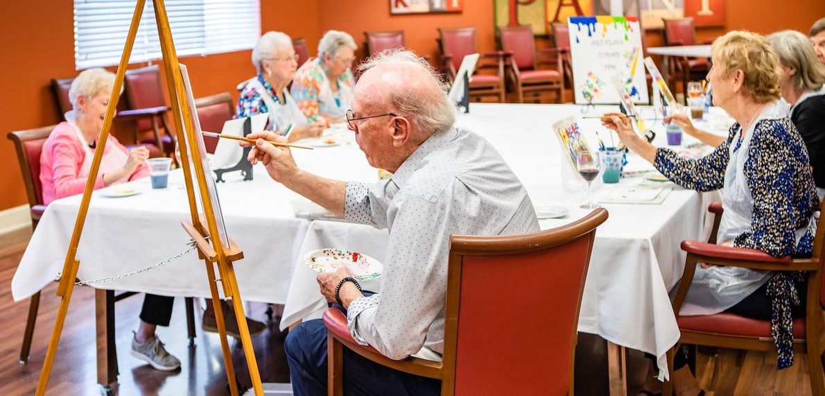 A group of senior residents in a painting class
