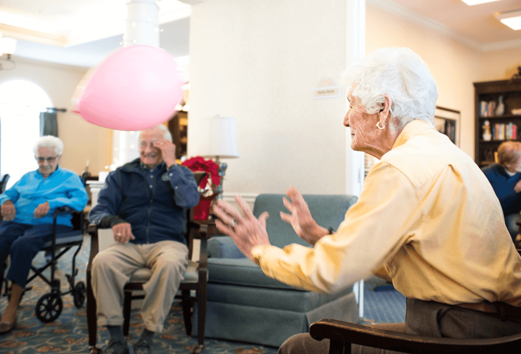 Senior residents playing a group game with a balloon